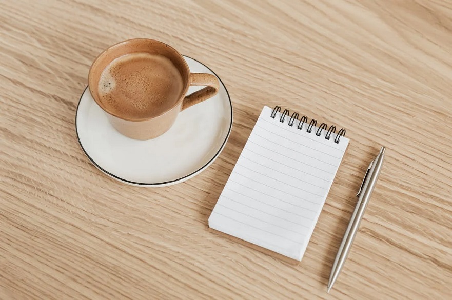 Coffee and a Notebook With a Pen